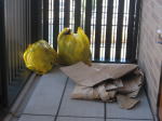 ２階の通路に置かれた、ゴミ袋とダンボール